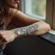 Poignet d'une femme avec tatouage floral détaillé en lumière naturelle